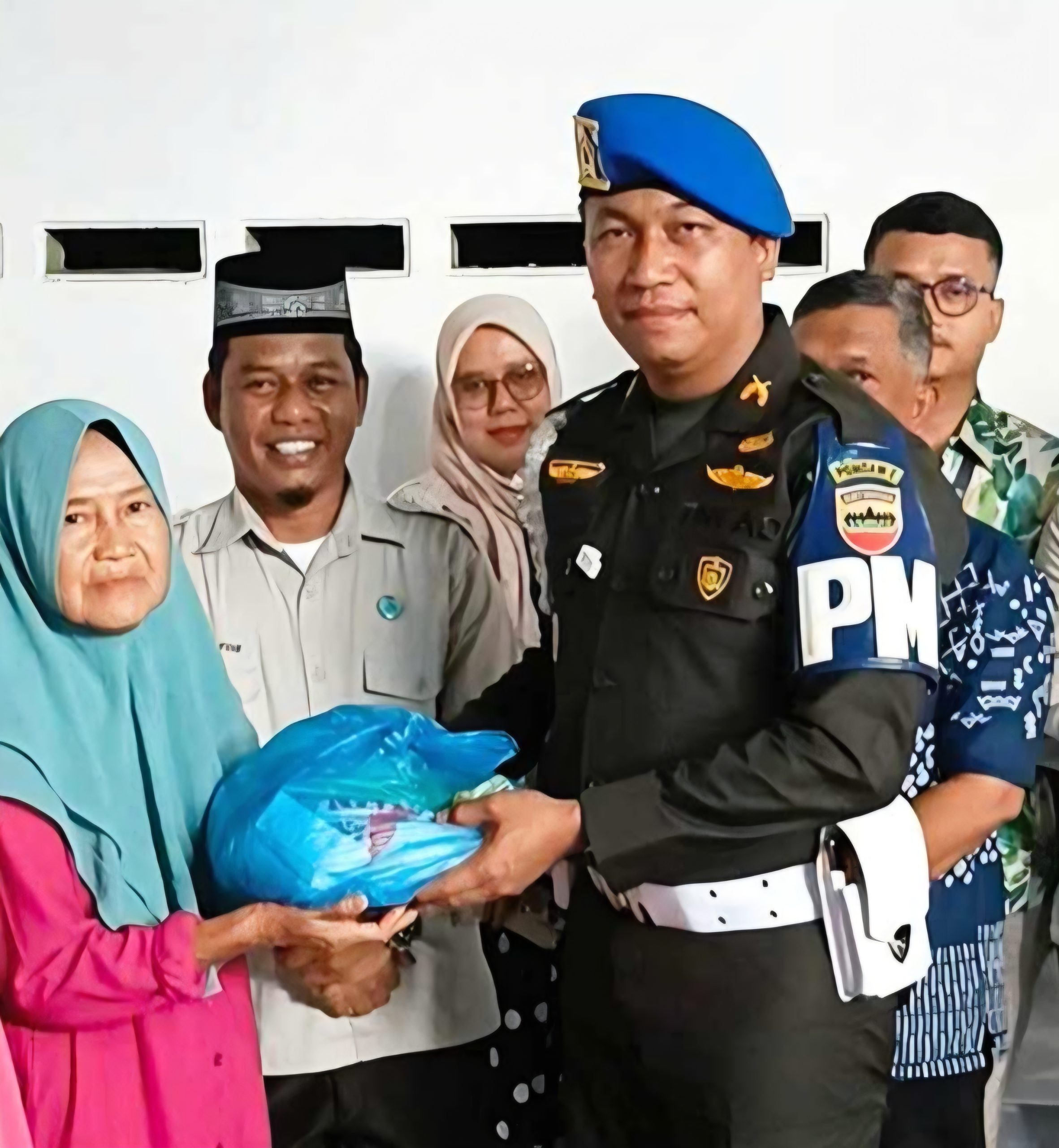Komandan Subdenpom I/5-1 Belawan Lettu CPM Pebruari P Tobing menyetahkan bantuan kepada warga. Foto; IST